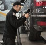 Man in Black Jacket Standing Beside Black Car