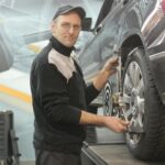 Man in Black Jacket Standing Beside Black Car